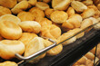 © Paweł Michałowski - Fresh bread rolls displayed in bakery behind glass. Golden crust buns arranged in rows. Food retail and baking concept with warm tones and appetizing presentation.
