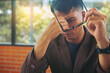 © Panumas - Tired businessman taking off glasses with eye pain during working and reading paperwork in office. Selected focus