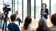 © Bonsales - Female speaker leading a business presentation at an event, engaging with audience and delivering professional speech