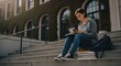 © RONNY - Young student studies on steps of a building, books, greenery in background