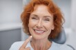 © Prazis Images - Beautiful Middle-Aged Woman with Red Hair Pointing to Her Perfect White Smile
