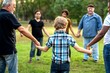 © Rawpixel.com - Diverse group holding hands outdoors.