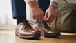 © pondolar - Man tying shoelaces on elegant brown leather shoes, dressing for work or special event
