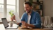 © pondolar - Happy man reviewing paper invoice at home with laptop and coffee on the table