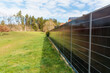 © JaRu Creative Studio - Vertical solar panel fence generating renewable energy along residential property boundary, modern photovoltaic system, sustainable technology, clean power solution