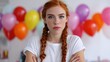 © OleksandrZastrozhnov - Young caucasian female with red hair standing in front of colorful balloons