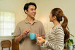 © MIND AND I - Happy Young Asian Couple Smiling and Drinking Coffee Together at Home