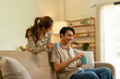 © MIND AND I - Happy Young Asian Couple Smiling and Drinking Coffee Together at Home