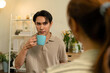 © MIND AND I - Man Smiling at Partner During Coffee Conversation at Home