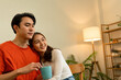 © MIND AND I - Young Asian Couple Sharing a Loving Moment with Coffee at Home