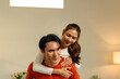 © MIND AND I - Playful Young Asian Couple Enjoying a Piggyback Ride at Home