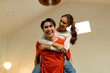© MIND AND I - Playful Young Asian Couple Enjoying a Piggyback Ride at Home