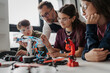 © Halfpoint - High school students working on robotics project with their teacher.