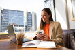 © Westend61 - Smiling businesswoman working on laptop with coffee in cafe indoors