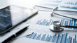 © Yuliani - Detailed statistical analysis and financial planning for healthcare services, represented by medical equipment and business charts