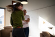 © TrueShot | Westend61 - Couple laughing and dancing together in living room at home