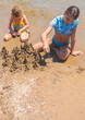 © yanadjan - Children playing with sand on the beach. Selective focus.