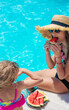 © yanadjan - Children eat watermelon near the pool. selective focus.