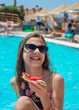 © yanadjan - girl eating watermelon near the pool. selective focus.