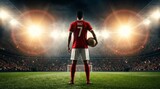 Rear view of a professional soccer player wearing a red jersey with the number seven, standing in a large stadium under bright floodlights while holding a ball.