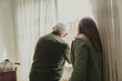 © Luis - Senior man and adult daughter looking out window