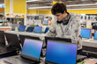 © Светлана Мищенко - Teenage boy comparing laptops in an electronics store and choosing a device. Technology shopping, education, digital lifestyle and consumer purchase decision concept