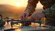 © Viktor - Soldier builds drone with tools on table outdoors at sunset. Military tech assembly, hands work on parts, evening sky backdrop. Manual labor skill, engineering, and repair.