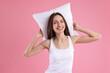© New Africa - Beautiful woman with pillow on pink background