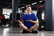 © New Africa - Happy young man with jar of protein powder in gym