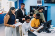 © Marcos - Diverse group of young university students and hispanic teacher using computer in an Academic Environment. Multicultural latin people in technology class in classroom in Latin America