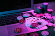 © Pixel-Shot - Laptop with playing cards and poker chips on green table, closeup
