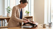 © Владлена Демидова - Businesswoman unpacking laptop and notebook from leather bag at desk