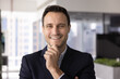 © fizkes - Modern corporate ceo. Headshot happy successful late 30s man energetic business leader entrepreneur executive look at camera with confident smile touch chin. Profile branding portrait for social media
