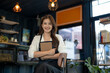 © apichat - Smiling woman small business owner managing her coffee shop