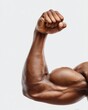 © NovaVision - Close-up of a muscular Black man's bicep flexing powerfully against a clean white background