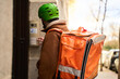 © Oscar - Courier delivering food ringing the doorbell at building entrance