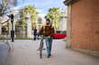 © Oscar - Man walking bicycle on city sidewalk