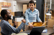 © DC Studio - Two diverse coworkers organizing the shipment of products in a small business logistics center, exemplifying the manual and tech driven processes of modern retail logistics. Import export.