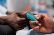 © DC Studio - Glucose level measurement in drugstore, african american hands closeup. Diabetes diagnosis, pharmacist measuring patient blood sugar with glucometer medical instrument, close view