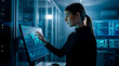 © Rendara Studio - Technology specialist woman analyzing global data on touchscreen monitor inside server room
