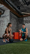 © master1305 - Personal trainer consulting woman during rest between exercises in functional training gym. Concept of fitness coaching, recovery time, workout planning and personalized training support
