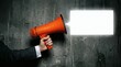 © Candra - Loud Message Orange megaphone shouts against dark gray concrete wall.