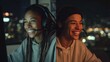 © Dina - Split screen video games concept: two diverse friends or couple in different cities, night-time, both wearing headsets, lit by gaming monitors, candid smiles and laughter