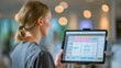 © Justlight - Medium shot of a medical professional consulting a tablet connected to an AIdriven patient flow management system displayed on a large screen with background softly out of focus.