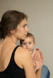 © Anna - young mother tenderly holds her six-month-old baby close. Happy Mother's Day. Tender maternal feelings. The joy of motherhood, tenderness, care, and soothing touches.