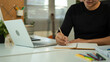 © Elder Stidio - Focused business man working on laptop computer making notes sitting at home office desk. Young adult male professional manager doing marketing research writing checklist on paper at workplace