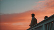 © Sopho - man with glass of wine gazes at sunset from balcony feeling joy and relaxation