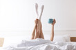 © New Africa - Woman with cup of coffee in bed at home, closeup