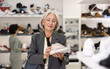 © JackF - Elderly female shopper purchases sneakers in shoe store