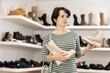 © JackF - Adult woman buyer chooses pair of high boots in shoe store